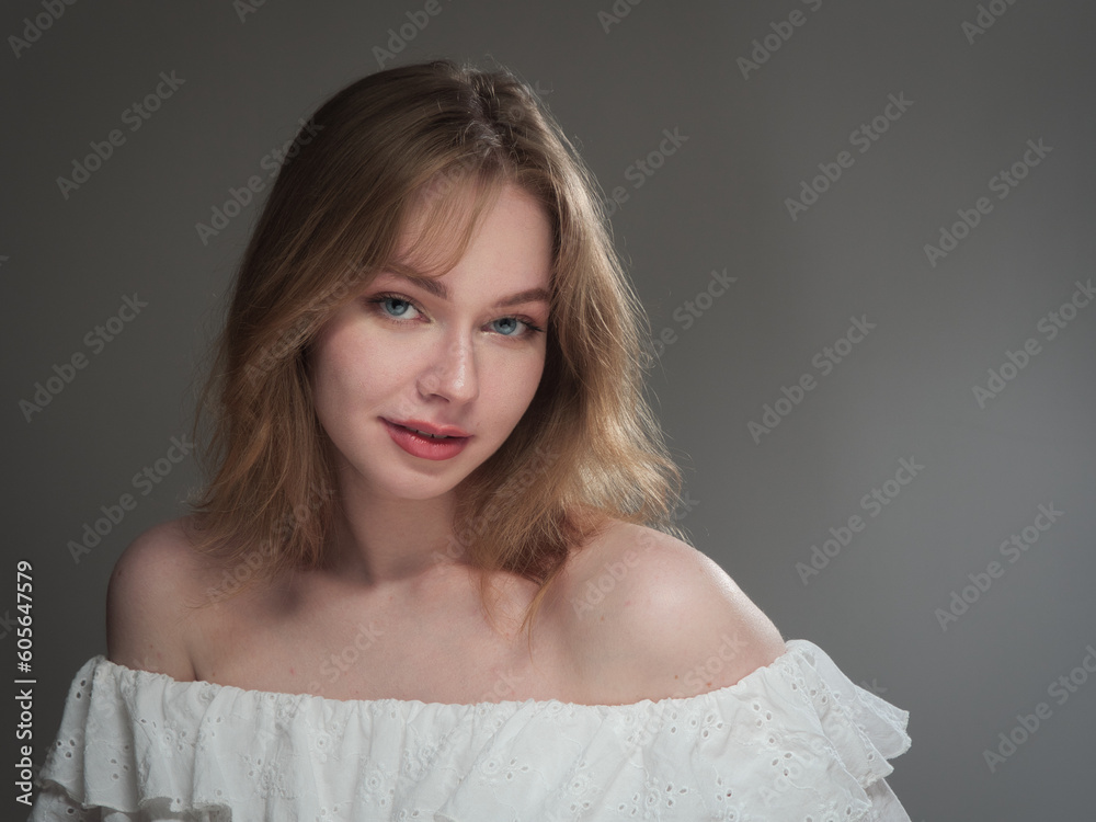 portrait of a beautiful girl with blue eyes on a gray background in the studio portrait of a beautiful girl with blue eyes on a gray background in the studio