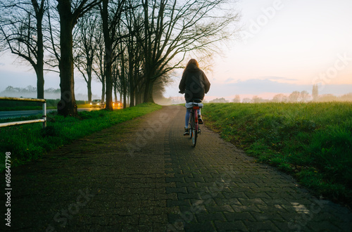 Woman cyclist riding on bicycle in the park in springtime.