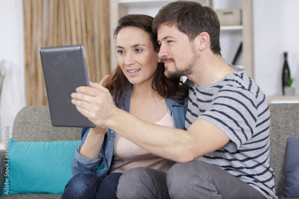 cheerful couple using digital tablet at home cheerful couple using digital tablet at home