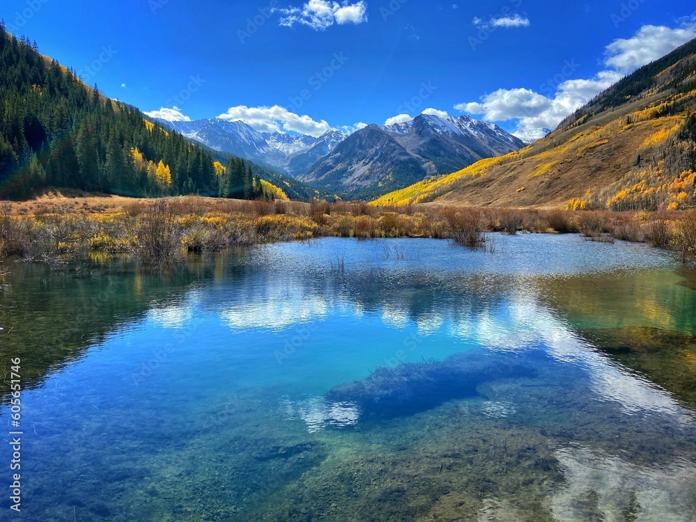 Beautiful scenery of Aspen, Colorado with high mountains and fall trees reflected in the blue lake