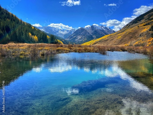 Beautiful scenery of Aspen, Colorado with high mountains and fall trees reflected in the blue lake