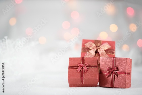 Red Christmas gift boxes decorated with snowflakes and bokeh lights in the background.