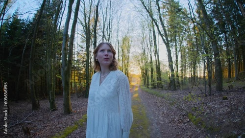 red hair girl walking in a forest