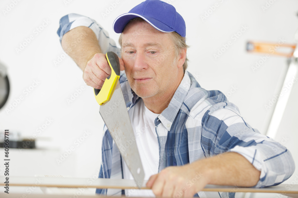 a senior carpenter sawing wood a senior carpenter sawing wood