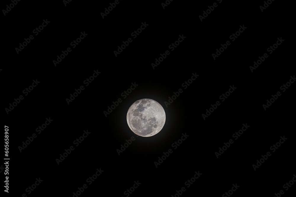 Beautiful view of the full moon shining in the dark, cloudless sky Beautiful view of the full moon shining in the dark, cloudless sky