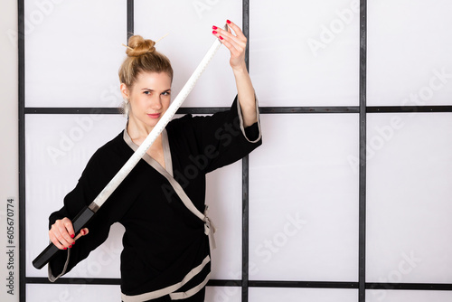 Attractive girl in kimono and Hair sticks against white background holds katana sword