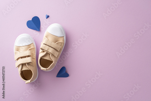 Sweet son celebrates Father's Day with his proud Dad. Top view of little boy's sneakers, and heart-shaped props on a lilac background with an empty space for text