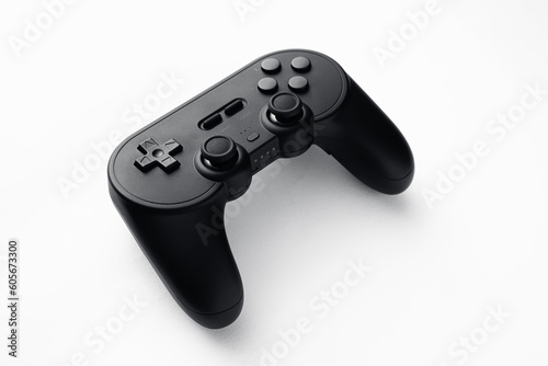 Video game controller, online games. Photo of black wireless joystick isolated over white background. Online and offline games, multiplayer fun, eSports. Black and white, game design.