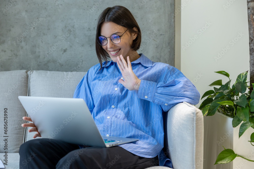 Joyous female greeting someone on the laptop screen Joyous female greeting someone on the laptop screen