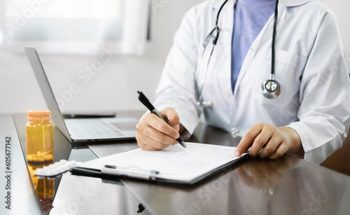 The female doctor sat and checked the patient s history and used a laptop to record patient information at the hospital. Medical concepts and interests