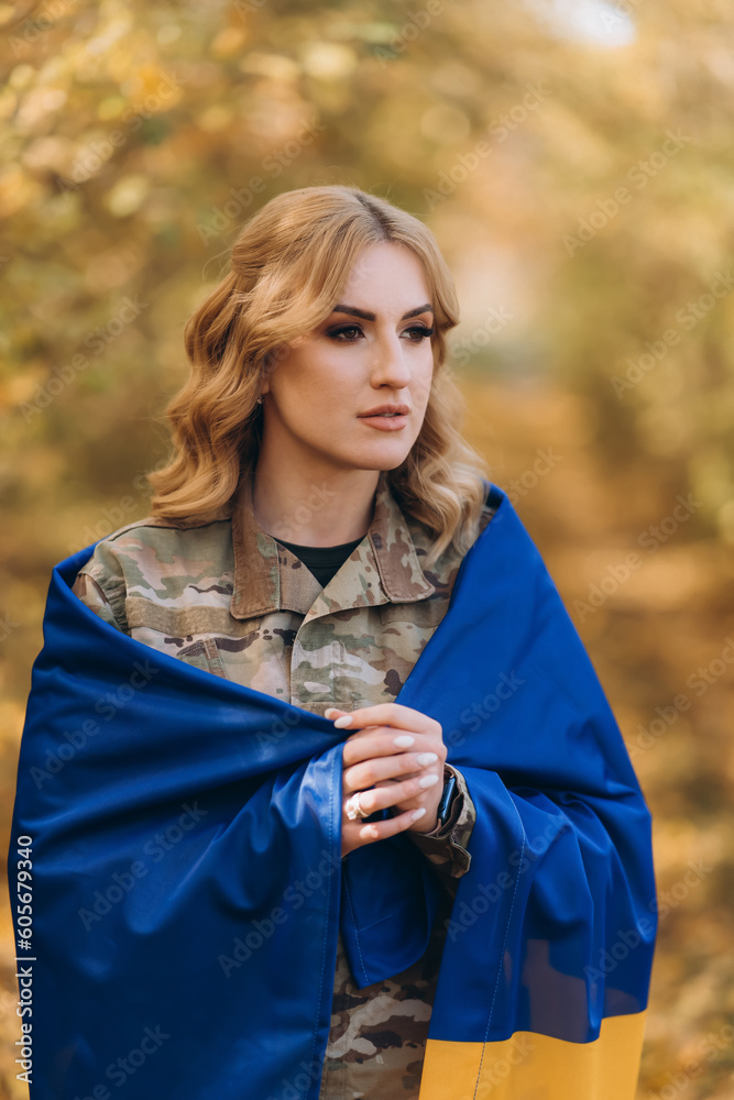Obraz premium A Ukrainian military woman with a Ukrainian flag.