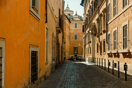 A narrow street with a yellow building in Rome © almostfuture