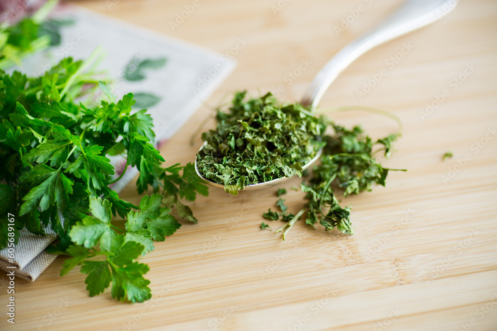 dried parsley in a spoon next to fresh herbs. dried parsley in a spoon next to fresh herbs.