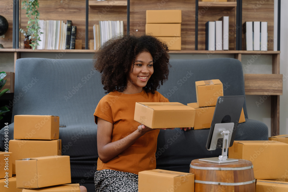 Startup or small business entrepreneur in e commerce, or logistics in remote startup at home. African American female owner selling online on the Internet, SME, shipping boxes, store success. Startup or small business entrepreneur in e commerce, or logistics in remote startup at home. African American female owner selling online on the Internet, SME, shipping boxes, store success.