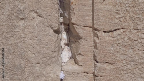Prayer Notes To God Are Tuck it into a Crevice At The Western Wall Of Jerusalem In Israel - close up photo