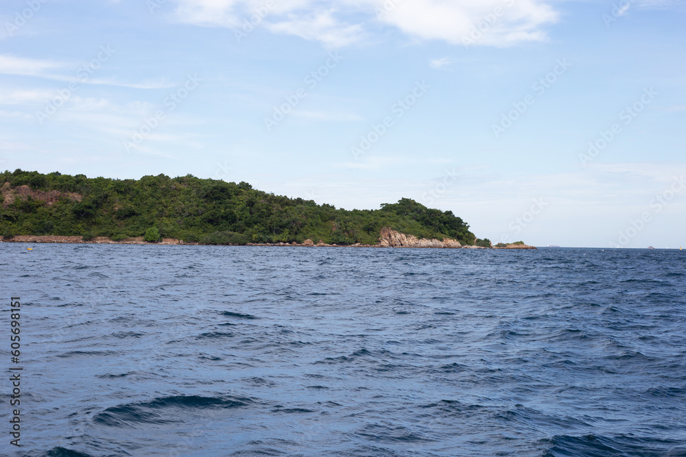 Island in the blue sea. Blue ocean water surface texture. Summer background.