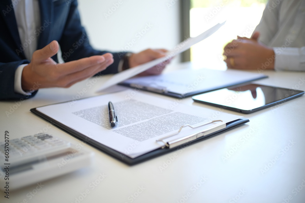 Sales manager giving advice application form document, considering mortgage loan offer for car and house insurance. Sales manager giving advice application form document, considering mortgage loan offer for car and house insurance.