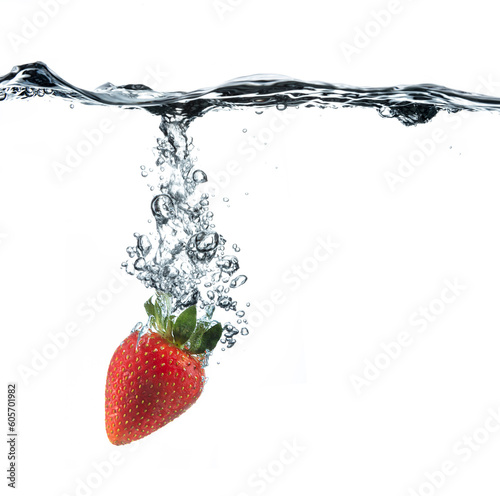 Single strawberry dropped into crystal clear water with a stream of bubbles