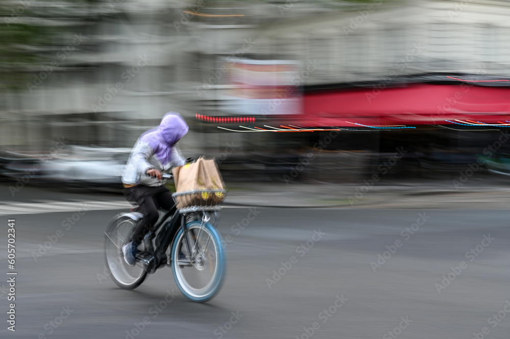 Blurred Man moving fast on bicycle on the street. Riding bike in the city. 