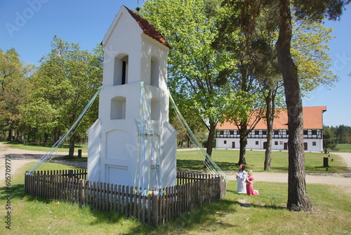 Modląca się mama z dzieckiem przed kapliczką. Olsztynek. Muzeum Budownictwa Ludowego. Polska - Mazury - Warmia.