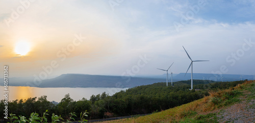 Panorama of Mountain and river landscape at sunset with wind turbines