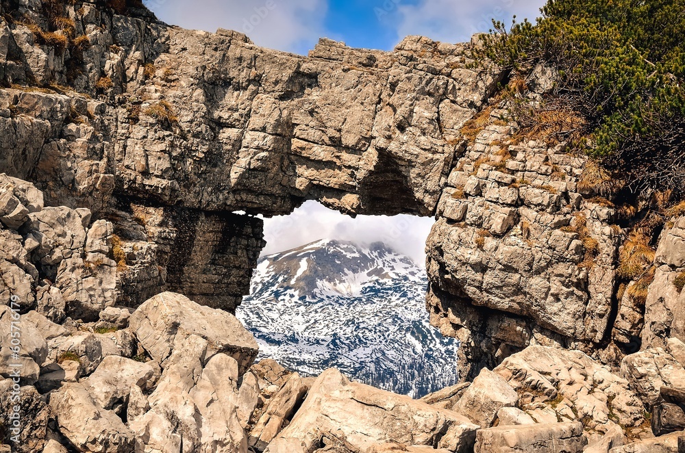 Rocky arch in Austrian Alps. View over mountains from rock window in Loser peak, Dead Mountains (Totes Gebirge) in Austrian Alps.