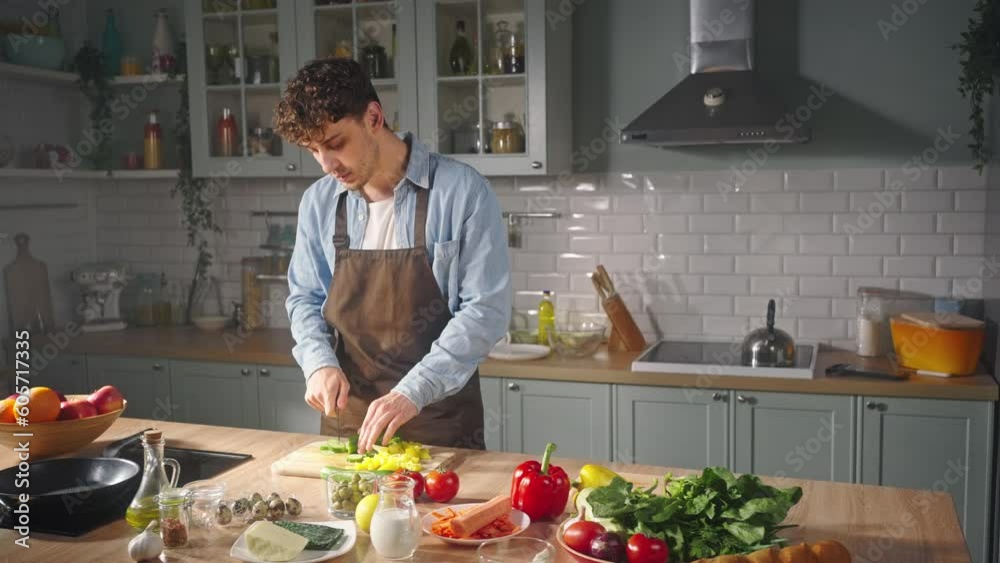 Young emotional happy couple in love enjoying together the process of cooking healthy food.