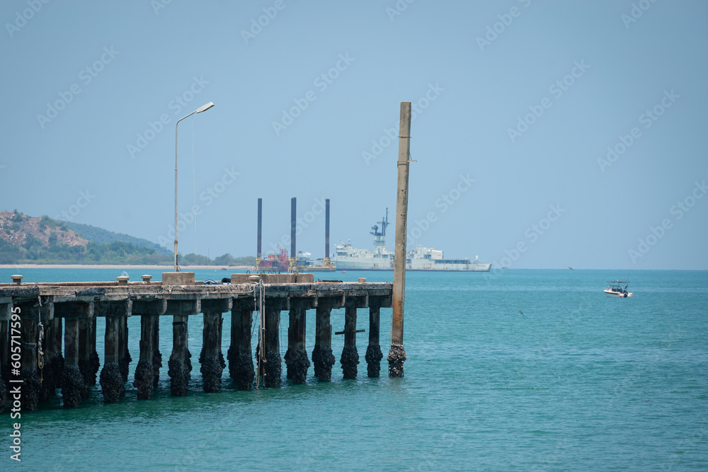 The seaside jetty or boat pier in sunny day with background of the island as far away. Transportation building in the outdoor. Selective focus.