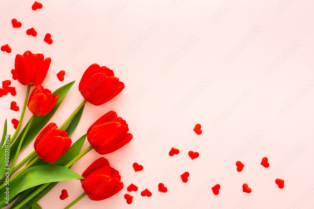 Fresh red tulips and hearts on pink background, concept of spring and holidays or Valentine's Day, top view, copy space