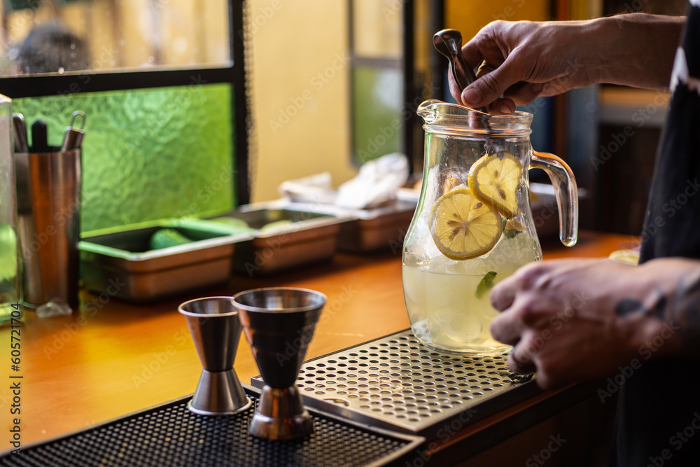 bartender preparando una jarra de limonada o gin tonic
