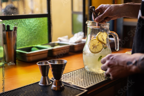 bartender preparando una jarra de limonada o gin tonic