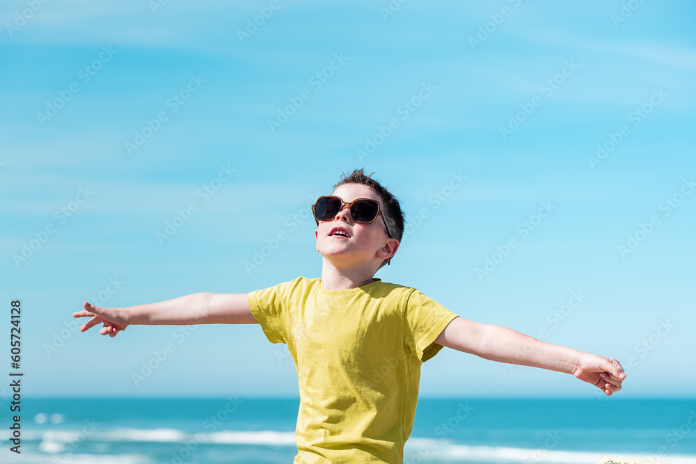 Boy with outstretched arms enjoying wind on beach Boy with outstretched arms enjoying wind on beach