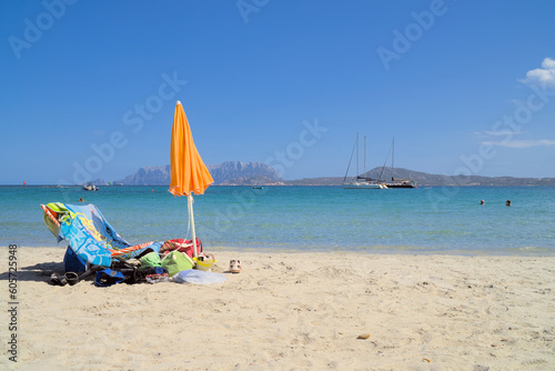 A sunbed and an umbrella by the sea on the Pellicano beach in Pittulongu, Italy