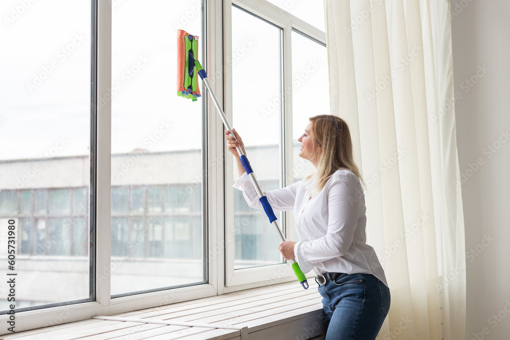 Washing window with special mop and cleaning services - housework and housewife concept Washing window with special mop and cleaning services - housework and housewife concept