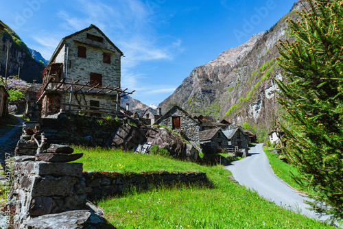 The typical houses of the Val Maggia mountain countries with its mountains and woods during a spring day, near the town of Foroglio, Switzerland - May 2023 photo