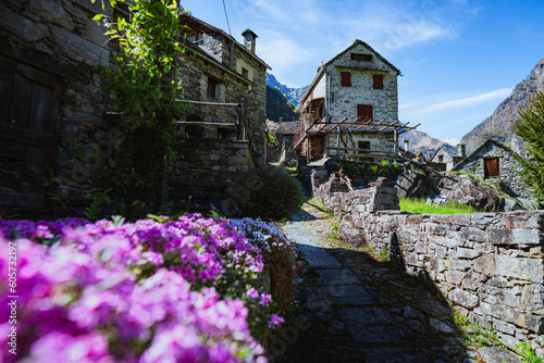 The typical houses of the Val Maggia mountain countries with its mountains and woods during a spring day, near the town of Foroglio, Switzerland - May 2023