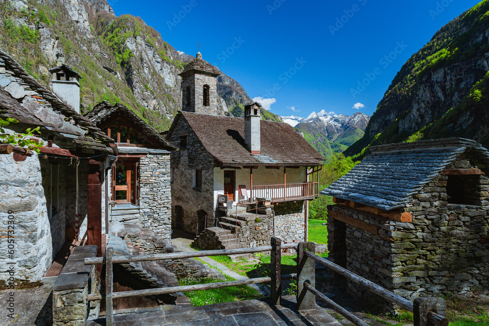 The typical houses of the Val Maggia mountain countries with its mountains and woods during a spring day, near the town of Foroglio, Switzerland - May 2023