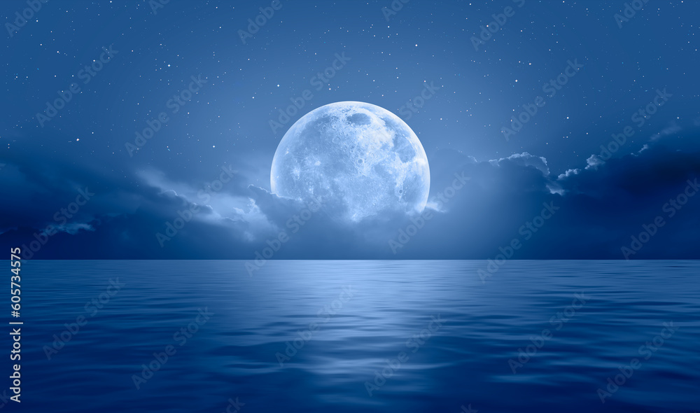Night sky with blue moon in the clouds over the calm blue sea, many sytars in the background  