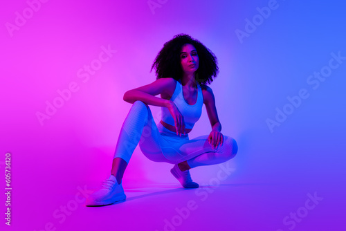Full body photo of cool fitness blogger squat advertise trendy outfit isolated on pink blue color neon background