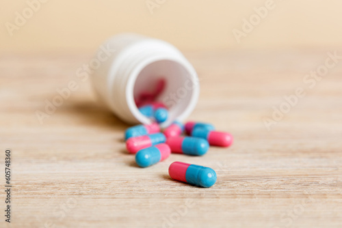 plastic medicine bottle with capsules of pills on colored background. Online pharmacy. Painkiller medicine and antibiotic drug resistance concept. Pharmaceutical industry