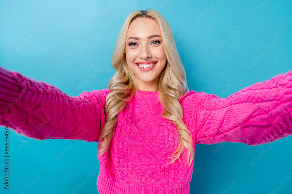 Fototapeta premium Photo of toothy beaming lovely girl with wavy hairdo dressed pink sweater doing selfie recording video isolated on blue color background