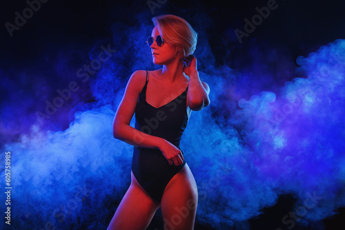 Portrait of female fashion model in sunglasses, in neon red blue light with neoned blue glowing. Vivid style, beauty cyber concept.