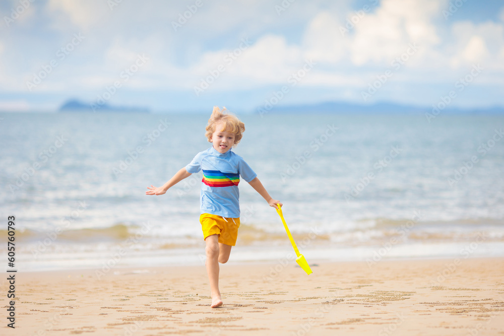Kids play on tropical beach. Sand and water toy.
