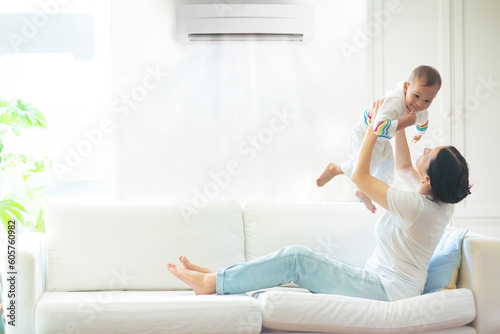 Mother and child with air conditioner remote