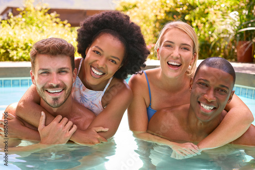Portrait Of Group Of Smiling Multi-Cultural Friends On Holiday In Swimming Pool