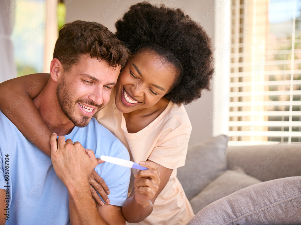 Excited Multi-Racial Couple In Bedroom At Home Celebrating Positive Pregnancy Test Result Excited Multi-Racial Couple In Bedroom At Home Celebrating Positive Pregnancy Test Result