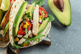 Tacos with grilled chicken, avocado, fresh tomatoes, limes. mexican burritos on a wooden board. banner, menu, recipe place for text, top view