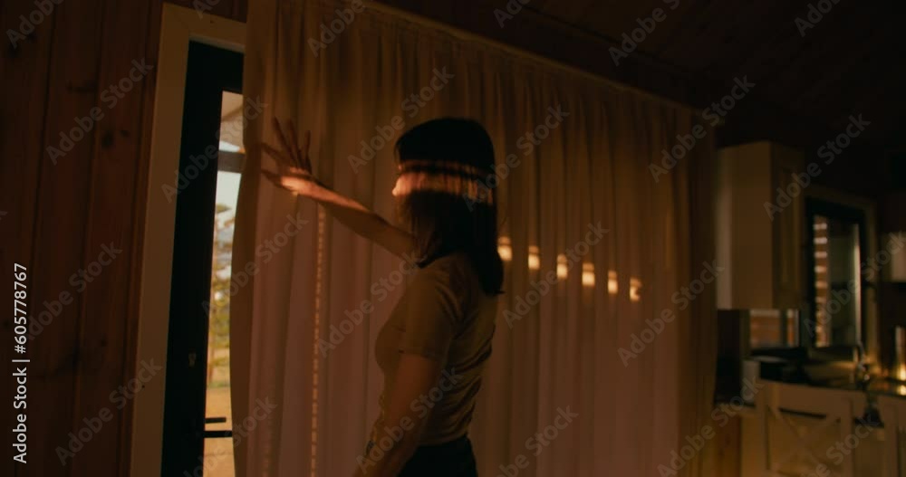 Woman opening curtain enjoying early morning sunrise at home, slow motion Woman opening curtain enjoying early morning sunrise at home, slow motion