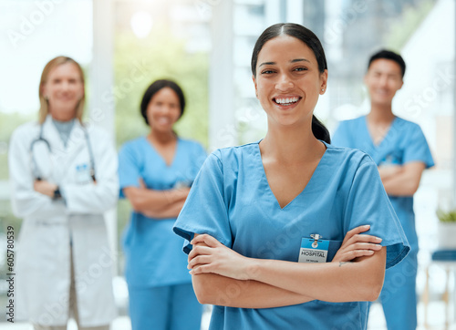Portrait, medical and a woman nurse arms crossed, standing with her team in the hospital for healthcare. Leadership, medicine and teamwork with a female health professional in a clinic for treatment