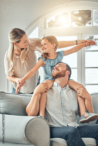 фотографія Mom, dad and child on sofa with flying game, piggy back and playful fun in living room for happy family